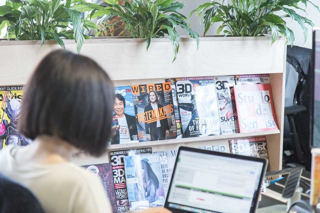 Someone working at Grammatik’s office with a Bookshelf Planter in the background 